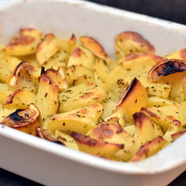 De græske kartofler med citron og oregano er en krydret version af kartoffelbåde eller ovnstegte kartofler.
