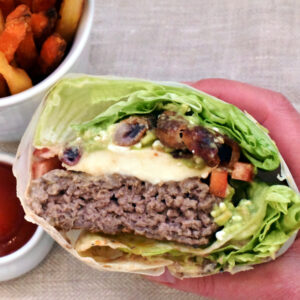 Burger i salatblade med bacon-løgringe