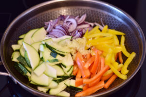 Grønsager steges på panden til thai kyllingefrikadeller